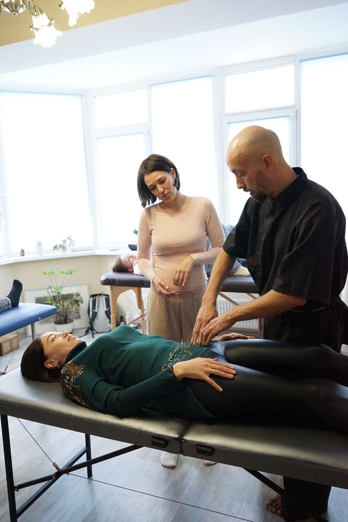 Holistic therapy session with professionals guiding a relaxation process indoors.